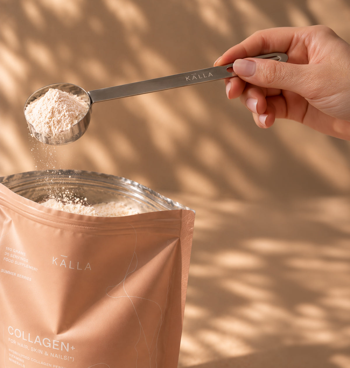 KÄLLA powder scoop with collagen powder in warm sunlight