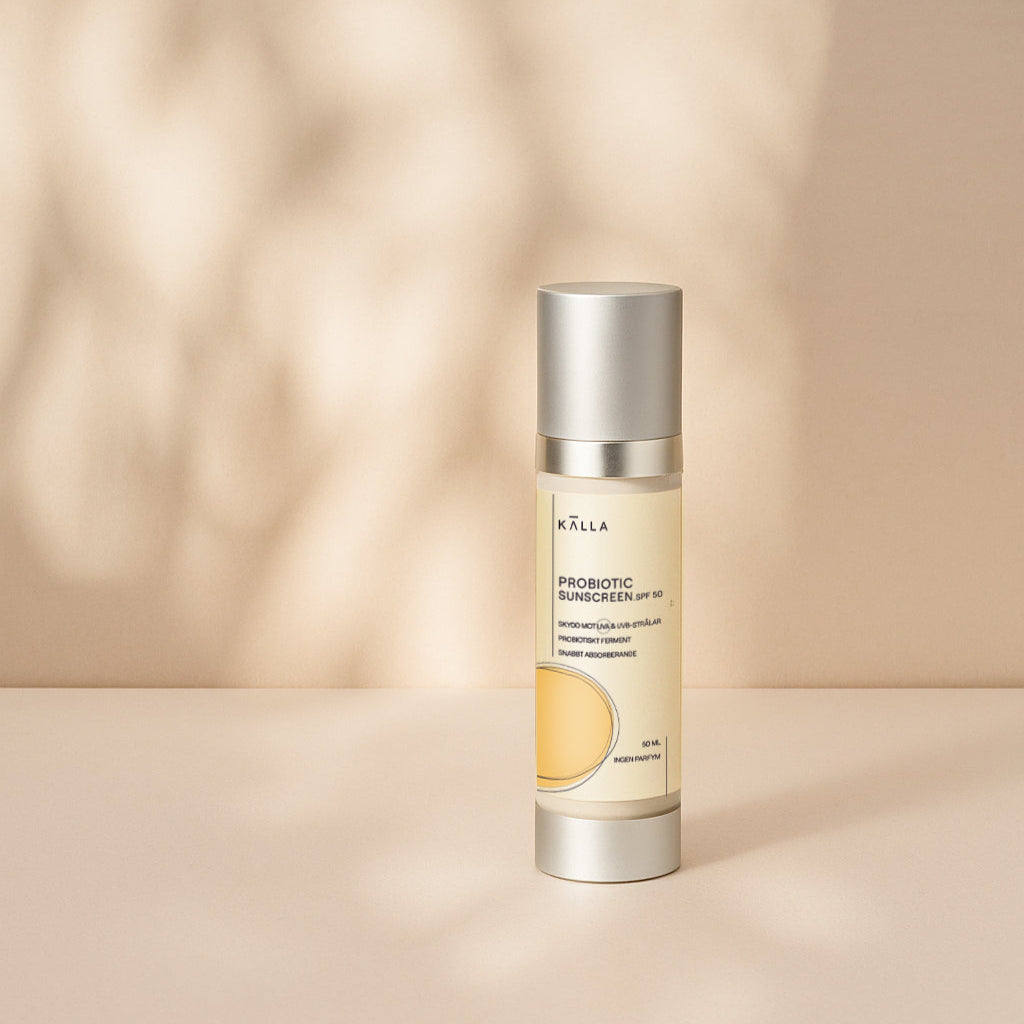 A pump bottle of Probiotic Sunscreen SPF50 by KALLA, positioned against a neutral background with a shadow cast across the surface.